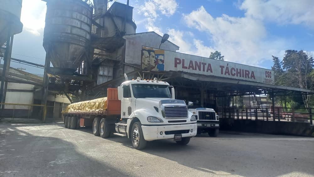 Camión con cemento empacado frente a planta