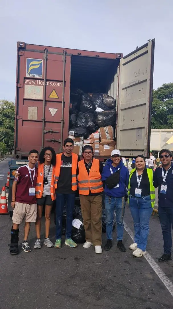 Equipo de apoyo frente al contenedor cargado con donaciones